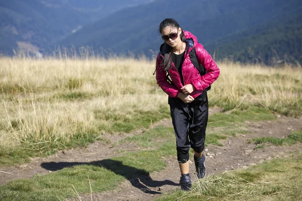 Mulher viajante com mochila caminhadas em montanhas com bonito — Fotografia de Stock