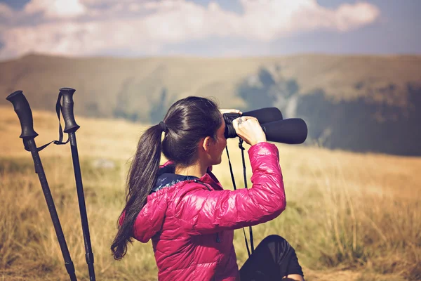 山の壮大な景色を楽しみながら双眼鏡で探してハイカー — ストック写真