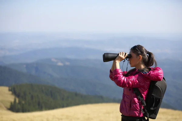 山の壮大な景色を楽しみながら双眼鏡で探してハイカー — ストック写真