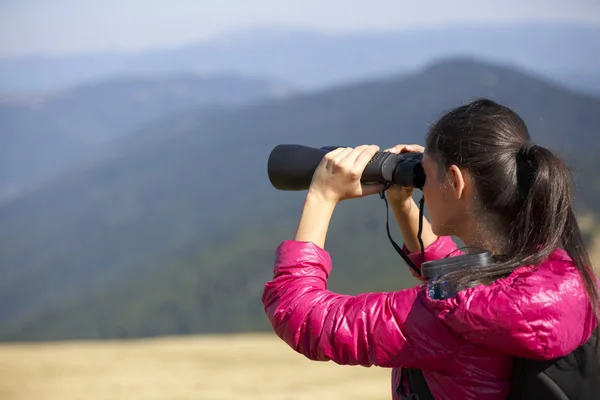 山の壮大な景色を楽しみながら双眼鏡で探してハイカー — ストック写真