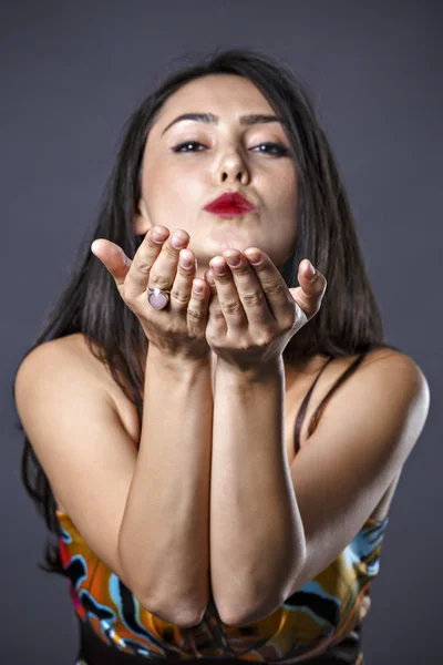 Beautiful young brunette in dress making hand gestures — Stock Photo, Image