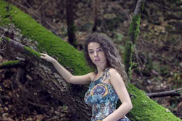 Portret van een mooie vrouw met krullend haar in de natuur — Stockfoto