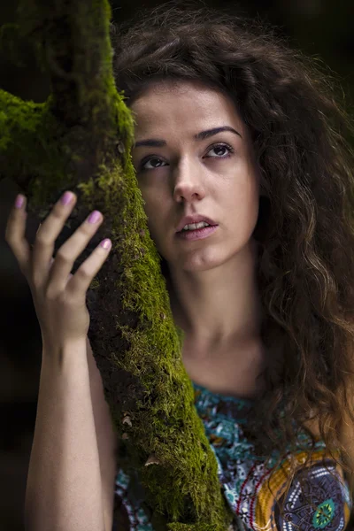 Portret van een mooie vrouw met krullend haar in de natuur — Stockfoto