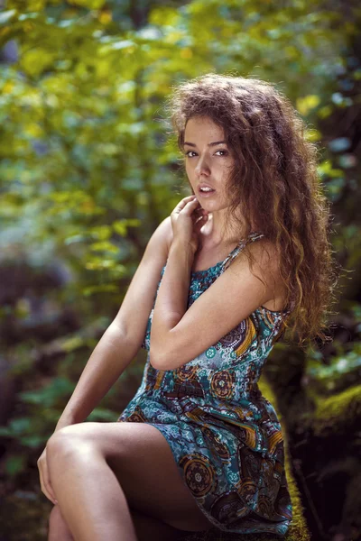 Retrato de una hermosa mujer con el pelo rizado en la naturaleza —  Fotos de Stock