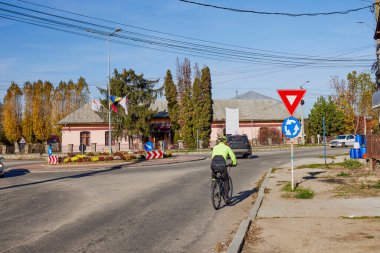 Yaşlı adam güzel bir sonbahar gününde bisiklet sürerek egzersiz yapıyor.