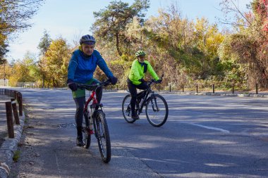Bisiklete binmeye tutkulu yaşlı bir adam oğluyla bisiklet sürüyor, güzel bir sonbahar gününün tadını çıkarıyor..