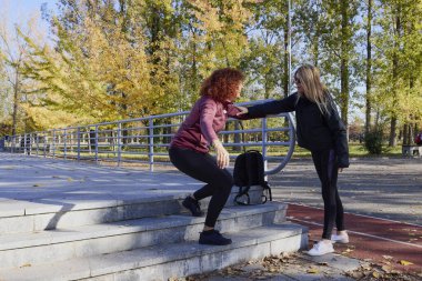 Güzel bir sonbahar gününde arkadaşıyla birlikte spor yapan orta yaşlı bir kadın.