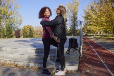 Güzel bir sonbahar gününde arkadaşıyla birlikte spor yapan orta yaşlı bir kadın.