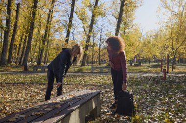 Güzel bir sonbahar gününde arkadaşıyla birlikte spor yapan orta yaşlı bir kadın.