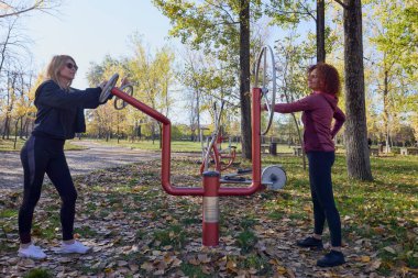 Güzel bir sonbahar gününde arkadaşıyla birlikte spor yapan orta yaşlı bir kadın.