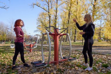 Güzel bir sonbahar gününde arkadaşıyla birlikte spor yapan orta yaşlı bir kadın.
