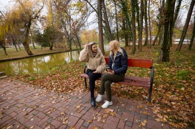 Bir sonbahar günü parkta yürüyen iki orta yaşlı kadın.