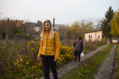 Orta yaşlı bir kadın yaşlı annesini ziyaret eder ve bahçede yürür.