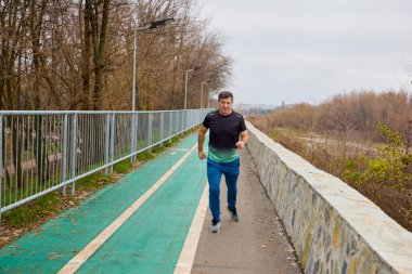 Orta yaşlı bir adam sabah egzersizleri yapar ve koşar..