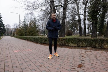 Bir sonbahar günü bir adam parkta yürür.