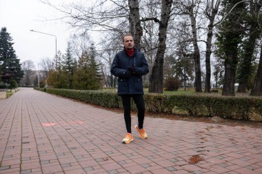 Bir sonbahar günü bir adam parkta yürür.