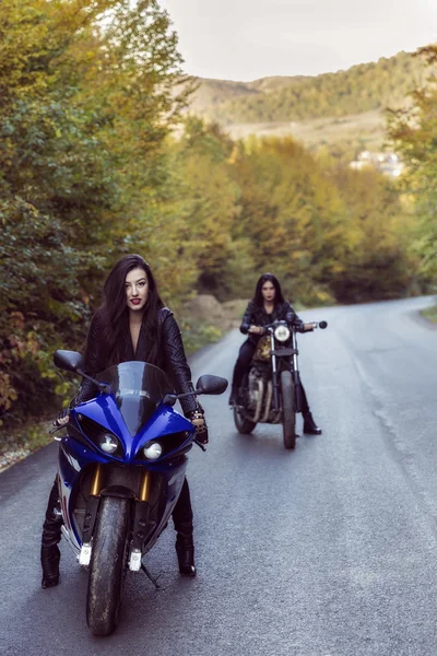 Dos hermosas mujeres apasionadas por las motocicletas, posando en natu —  Fotos de Stock