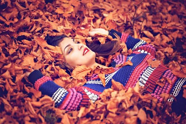 Φθινόπωρο γυναίκα που βρίσκεται πέρα από τα φύλλα και χαμογελαστό, κορυφαία άποψη — Φωτογραφία Αρχείου