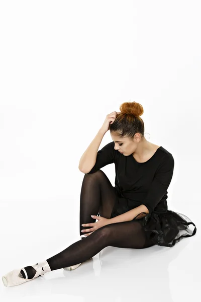 Ballerina posa sul pavimento isolato su uno sfondo bianco — Foto Stock