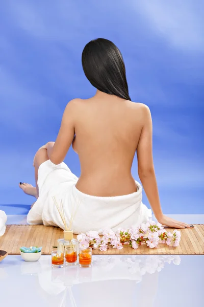 Vista traseira de mulher e usando toalha sentada no chão, isolado — Fotografia de Stock