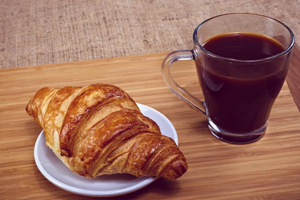 Café y croissant para el desayuno en mesa de madera rústica —  Fotos de Stock