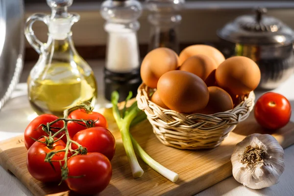 Huevos en una cesta con verduras Imagen de archivo