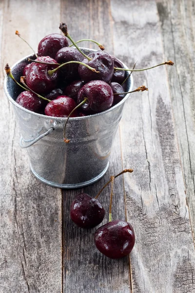 Wet Cherries in a Bucket on a Wooden Table — Stock Photo, Image