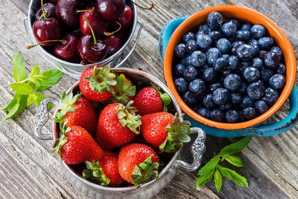 Körsbär, jordgubbar och blåbär i en skålar — Stockfoto