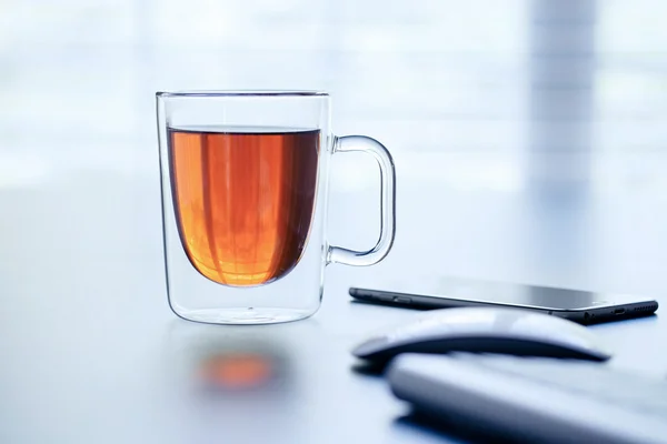 Tazza di tè di vetro su un tavolo Immagine Stock