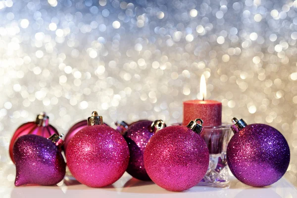 Bolas de Navidad púrpura y vela Imagen de archivo