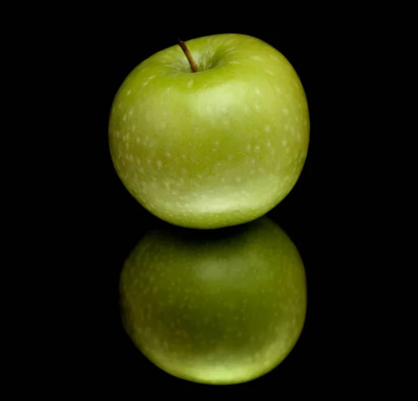 Manzana Verde Sobre Superficie Reflectante Aislada Sobre Negro — Foto de Stock