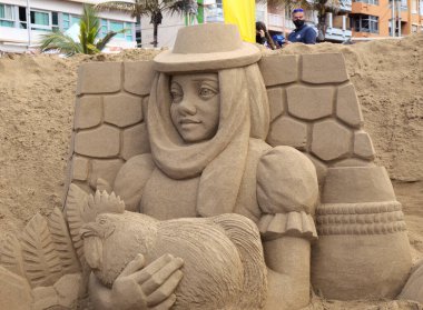 Las Palmas de Gran Canaria, İspanya - Düzenbaz 05: Ziyaretçiler, Las Canteras şehir plajında kumdan yapılmış doğum sahneleri olan Belen de Arena 'ya hayranlık duyuyorlar.