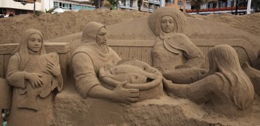 Las Palmas de Gran Canaria, İspanya - Düzenbaz 05: Ziyaretçiler, Las Canteras şehir plajında kumdan yapılmış doğum sahneleri olan Belen de Arena 'ya hayranlık duyuyorlar.