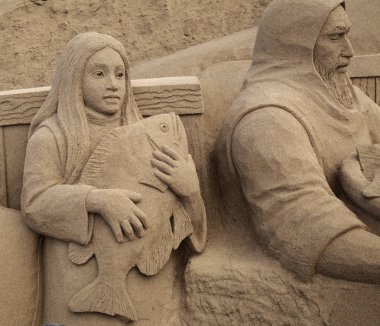 Las Palmas de Gran Canaria, İspanya - Düzenbaz 05: Ziyaretçiler, Las Canteras şehir plajında kumdan yapılmış doğum sahneleri olan Belen de Arena 'ya hayranlık duyuyorlar.