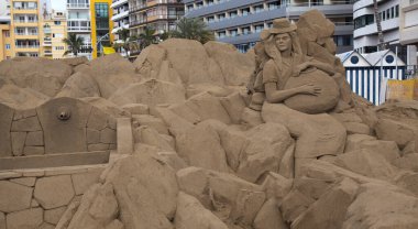 Las Palmas de Gran Canaria, İspanya - Düzenbaz 05: Ziyaretçiler, Las Canteras şehir plajında kumdan yapılmış doğum sahneleri olan Belen de Arena 'ya hayranlık duyuyorlar.