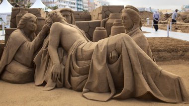 Las Palmas de Gran Canaria, İspanya - Düzenbaz 05: Ziyaretçiler, Las Canteras şehir plajında kumdan yapılmış doğum sahneleri olan Belen de Arena 'ya hayranlık duyuyorlar.