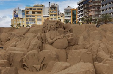 Las Palmas de Gran Canaria, İspanya - Düzenbaz 05: Ziyaretçiler, Las Canteras şehir plajında kumdan yapılmış doğum sahneleri olan Belen de Arena 'ya hayranlık duyuyorlar.