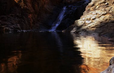Gran Canaria, adanın güney kesimindeki çılgın Barranco del Toro çevresindeki yürüyüş rotası boyunca uzanan manzaralar, mağaralar ve mağaralarla dolu, San Agustin tatil köyüne yakın, kış yağmurlarından sonra vadide sular akıyor.