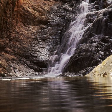 Gran Canaria, adanın güney kesimindeki çılgın Barranco del Toro çevresindeki yürüyüş rotası boyunca uzanan manzaralar, mağaralar ve mağaralarla dolu, San Agustin tatil köyüne yakın, kış yağmurlarından sonra vadide sular akıyor.
