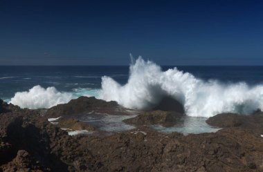 Gran Canaria, kuzey kıyısı, Punta Sardina Burnu 'nun çevresi, güçlü köpüklü okyanus dalgaları kıyı boyunca kırdıyor