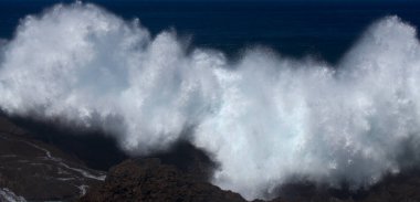 Gran Canaria, kuzey kıyısı, Punta Sardina Burnu 'nun çevresi, güçlü köpüklü okyanus dalgaları kıyı boyunca kırdıyor