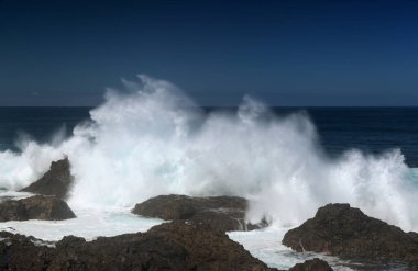 Gran Canaria, kuzey kıyısı, Punta Sardina Burnu 'nun çevresi, güçlü köpüklü okyanus dalgaları kıyı boyunca kırdıyor
