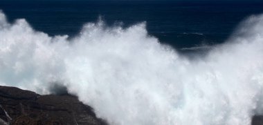 Gran Canaria, kuzey kıyısı, Punta Sardina Burnu 'nun çevresi, güçlü köpüklü okyanus dalgaları kıyı boyunca kırdıyor