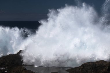 Gran Canaria, kuzey kıyısı, Punta Sardina Burnu 'nun çevresi, güçlü köpüklü okyanus dalgaları kıyı boyunca kırdıyor