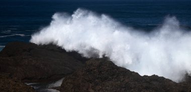 Gran Canaria, kuzey kıyısı, Punta Sardina Burnu 'nun çevresi, güçlü köpüklü okyanus dalgaları kıyı boyunca kırdıyor