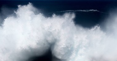 Gran Canaria, kuzey kıyısı, Punta Sardina Burnu 'nun çevresi, güçlü köpüklü okyanus dalgaları kıyı boyunca kırdıyor