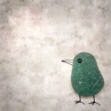 Şık desenli eski kağıt arka plan, deniz camı çakıl taşlarından yapılmış komik küçük kuşlar. 