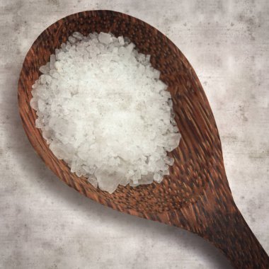 Kare biçiminde eski dokuma kağıt arka planda ahşap bir kaşık dolusu deniz ürünü.