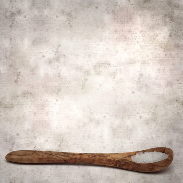 Kare biçiminde eski dokuma kağıt arka planda ahşap bir kaşık dolusu deniz ürünü.