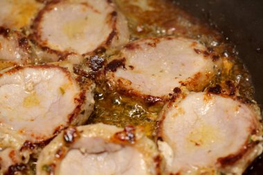 Tavada bol miktarda yağda kızartılmış domuz eti.